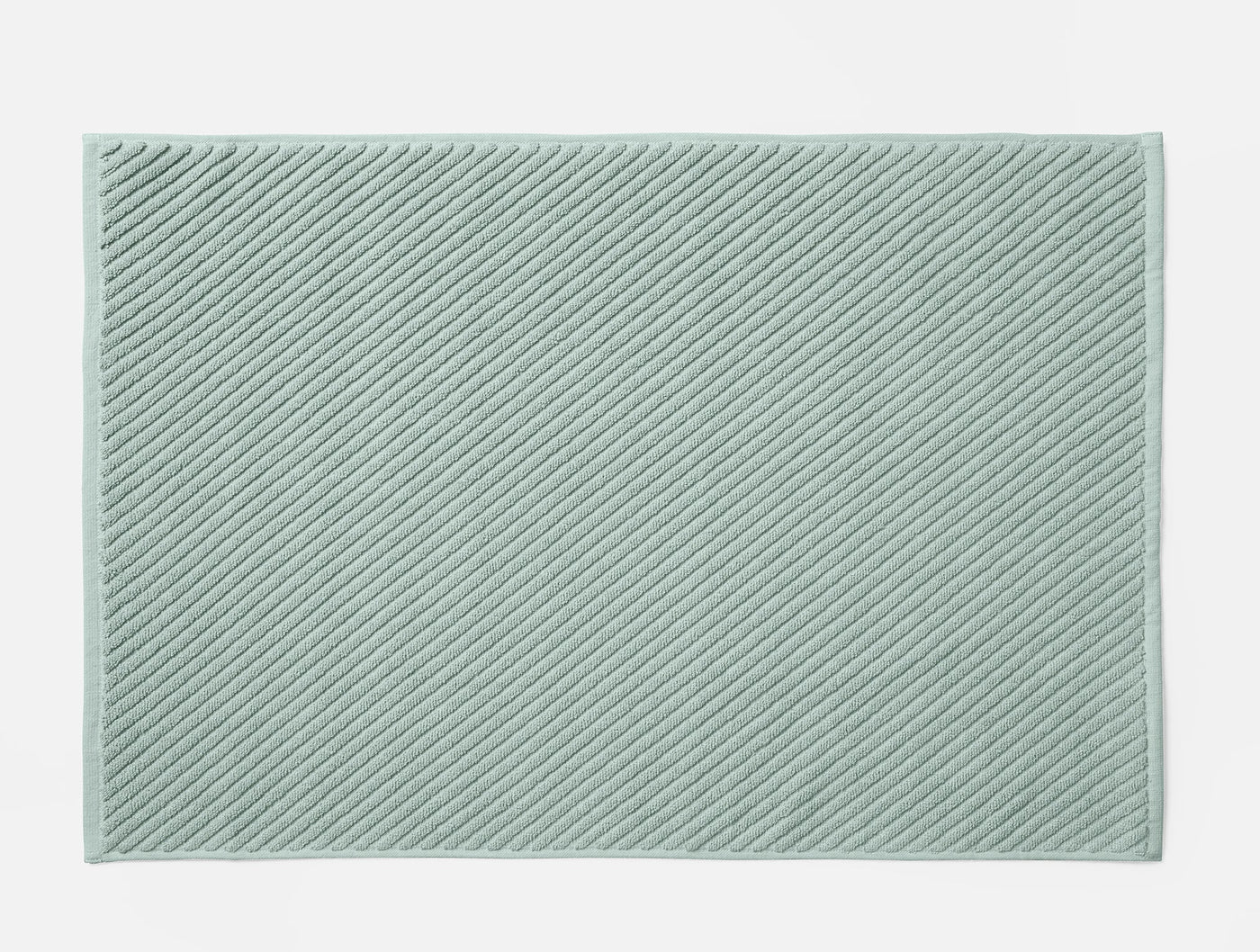 Coyuchi Air Weight bath rug in sage, diagonal ribbed twill texture, flat lay view.