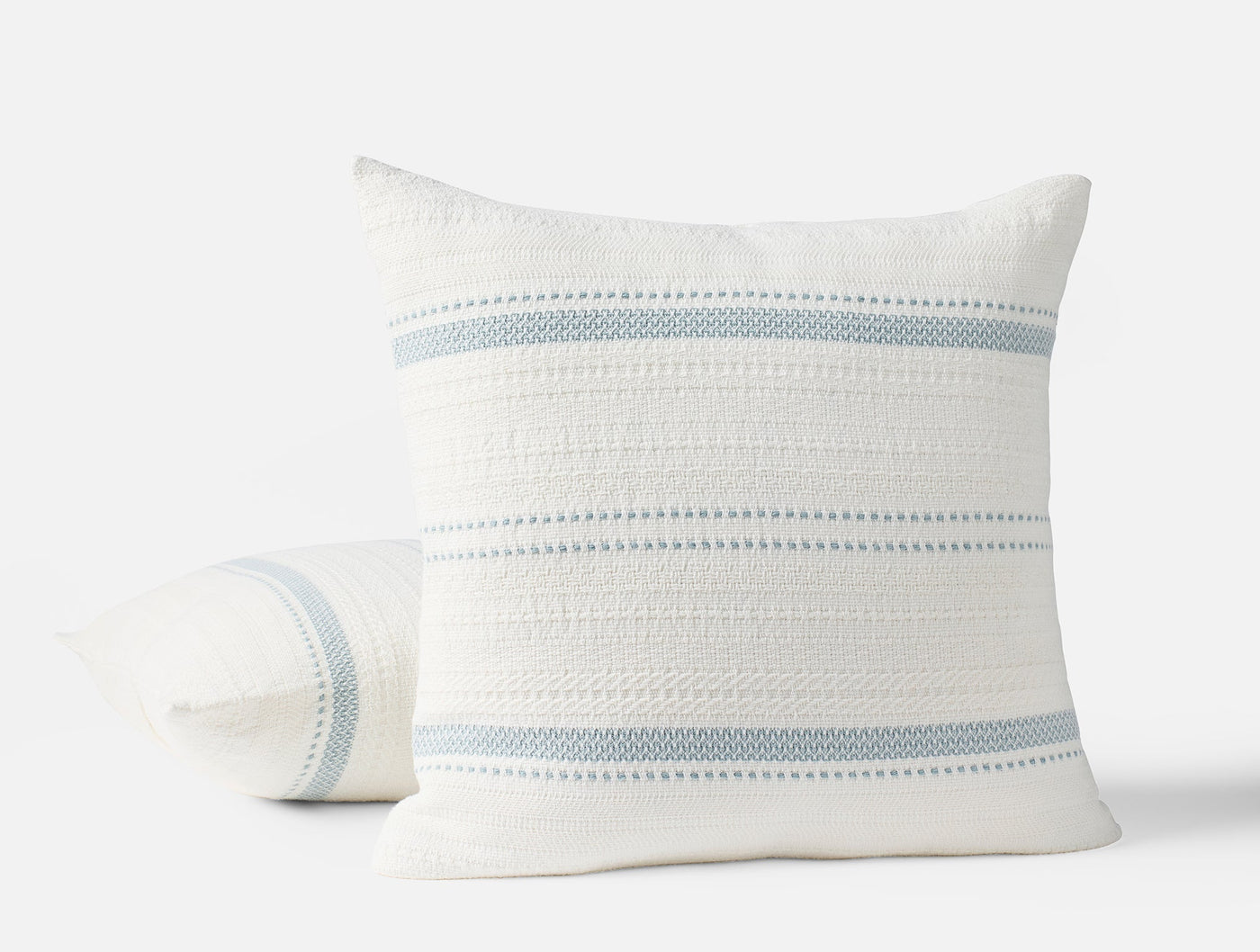 Coyuchi Bonita decorative pillow in white with dusty blue woven stripe detailing.
