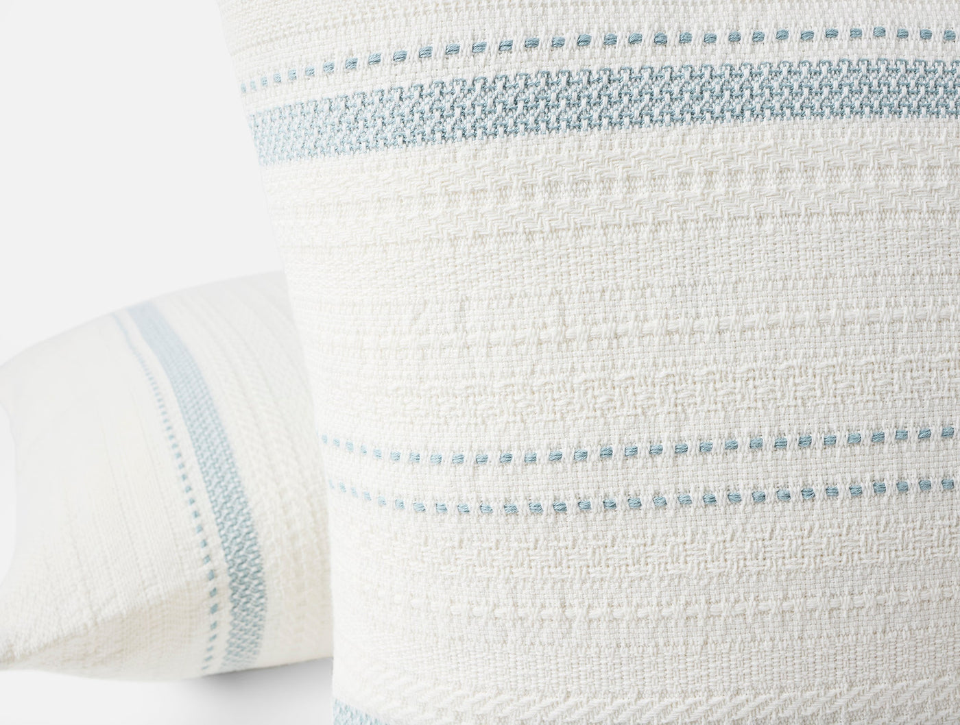 Close-up of Coyuchi Bonita pillow's woven texture with pale blue stripe detailing.