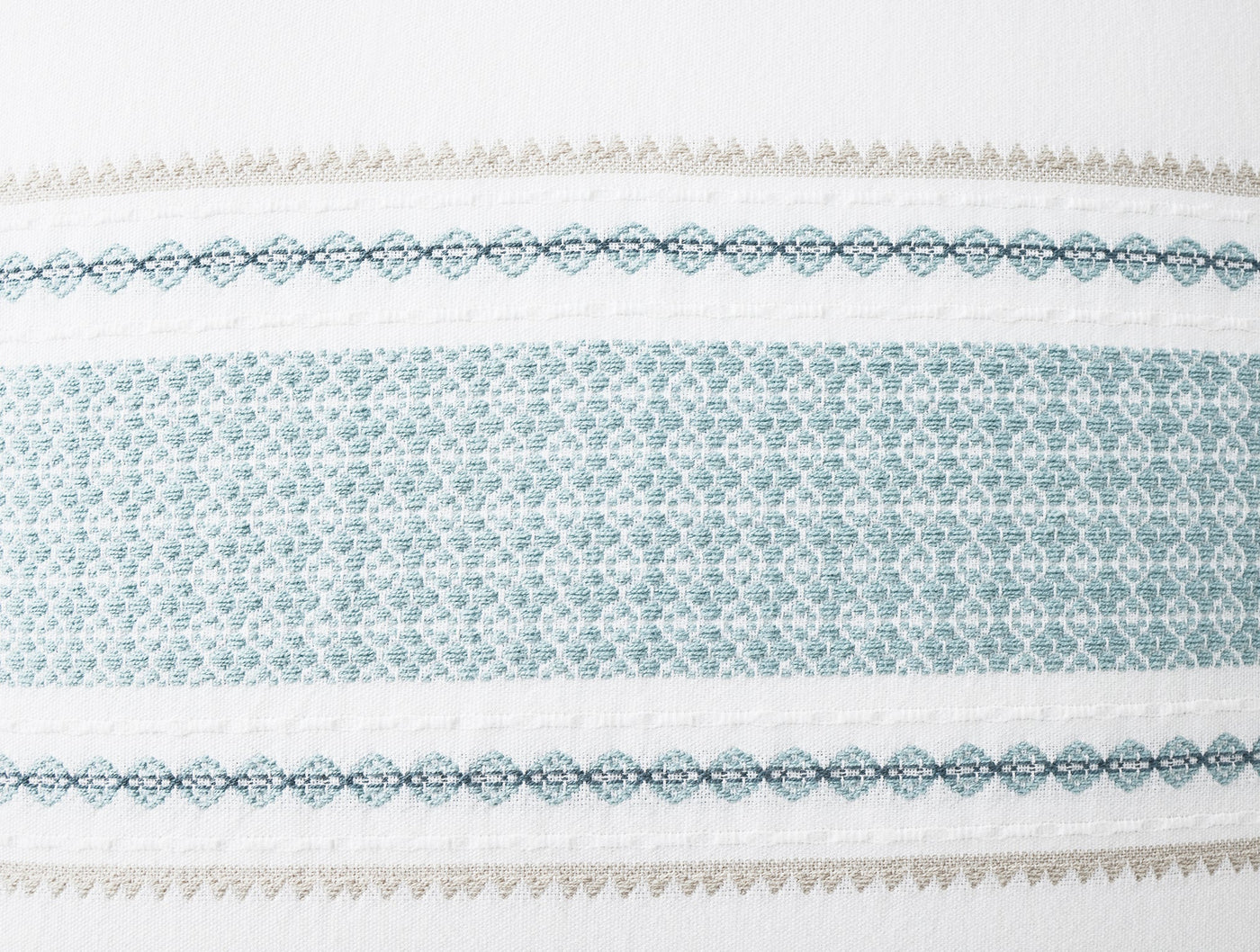 Close-up of Coyuchi Cabrillo sham border with teal geometric embroidery and taupe lace trim.