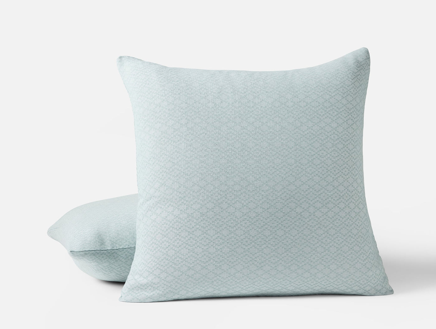 Two seafoam Coyuchi Capitola pillow shams stacked, showing subtle diamond jacquard weave.