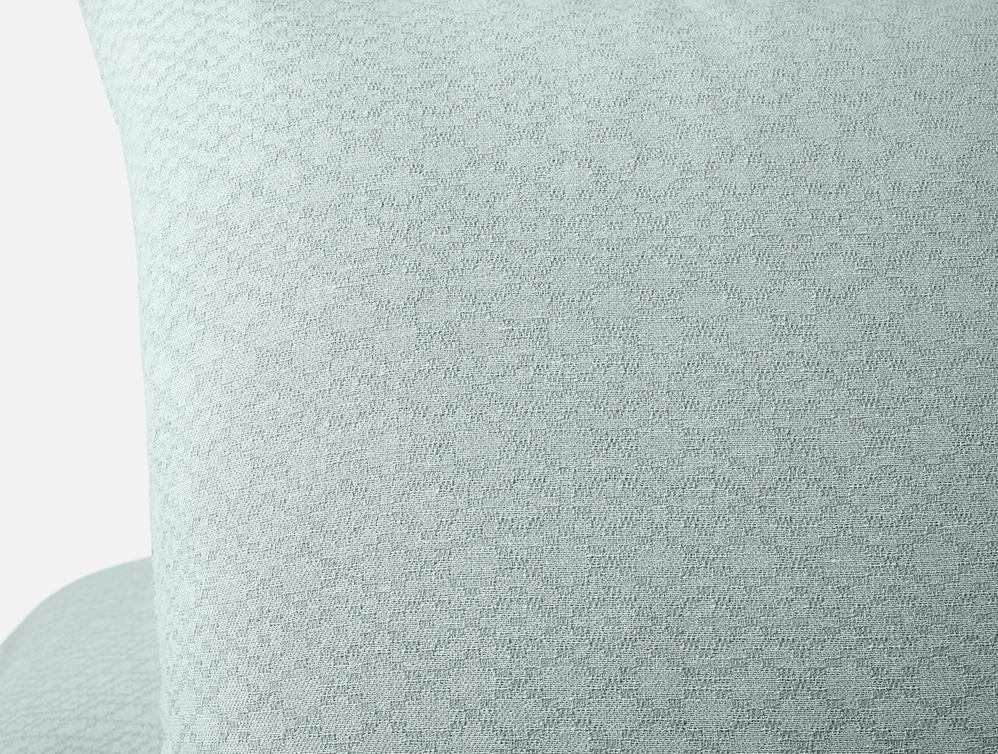 Close-up of Coyuchi Capitola sham in mist blue, showing woven diamond-pattern texture.