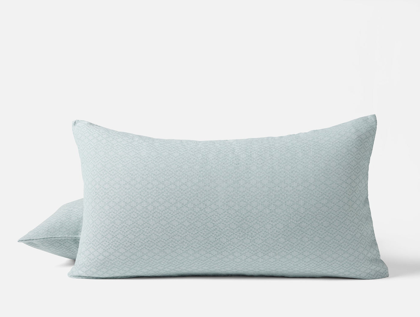 Misty blue Coyuchi Capitola shams showing subtle diamond matelassé texture, stacked pair view.
