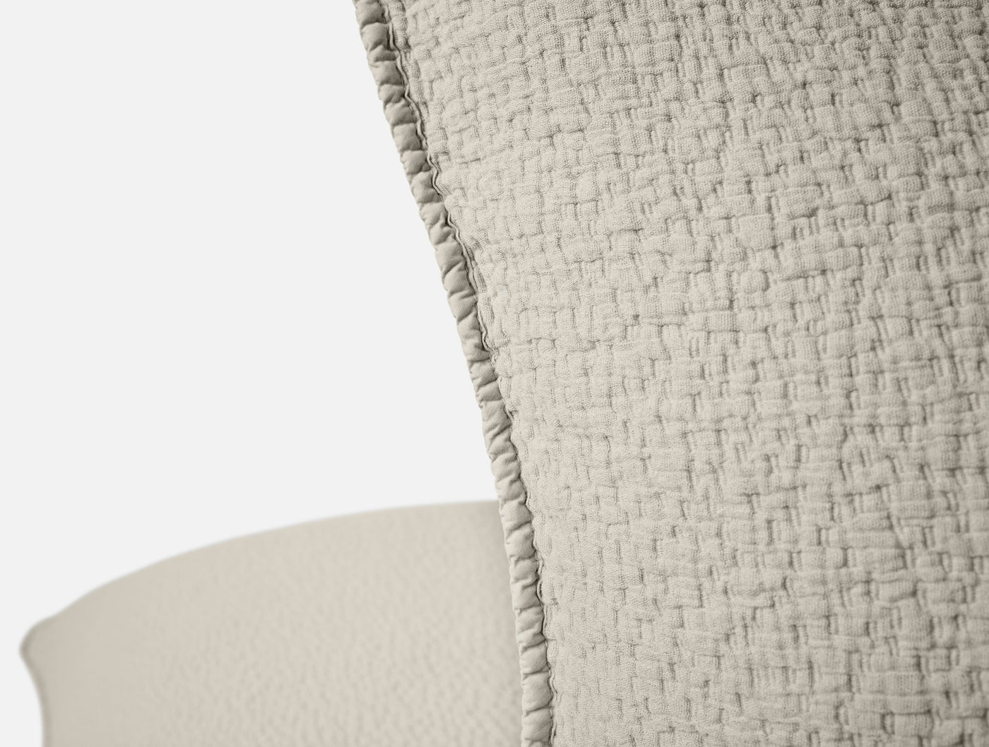 Close-up of Coyuchi Cascade Matelasse sham edge, showing ruffle trim and woven texture in natural.