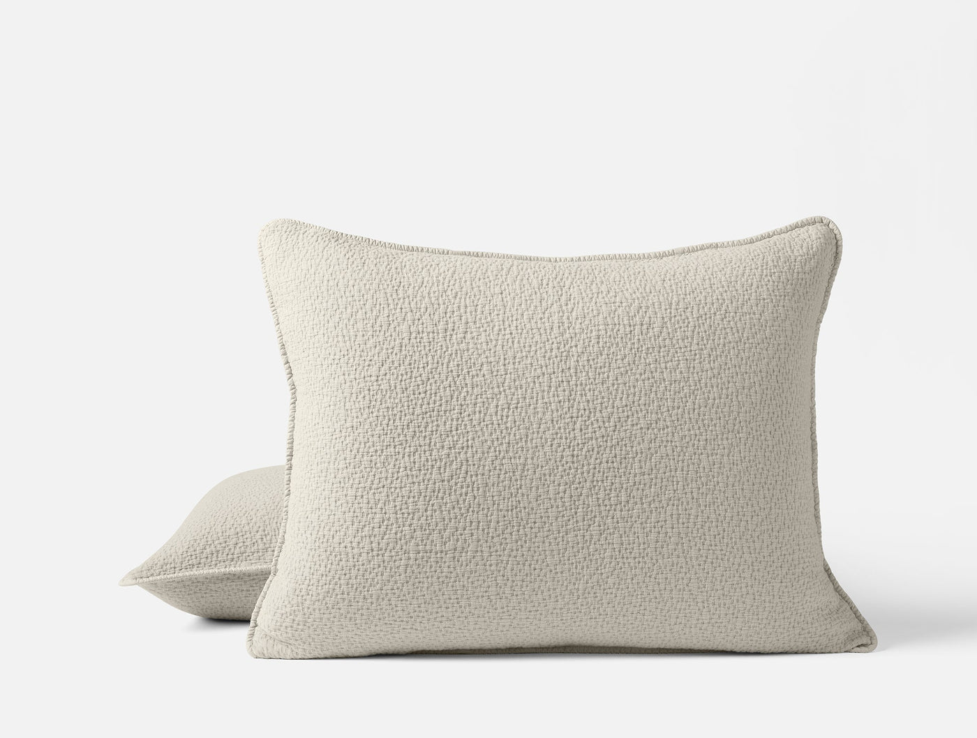 Ivory boucle-textured matelasse pillow shams, pair shown front and back views.