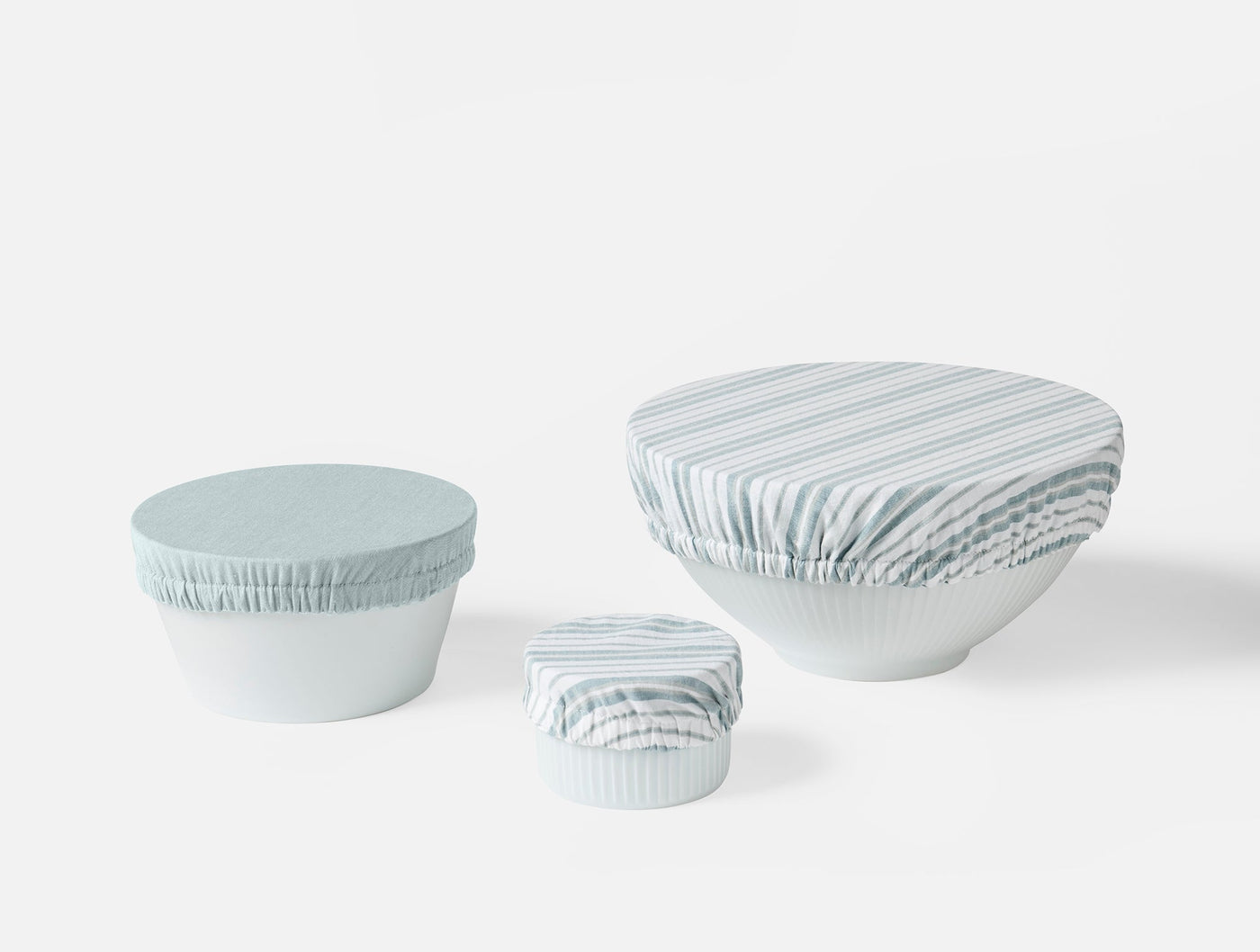 Three Coyuchi Conserve bowl covers in sage stripe, shown in small, medium, and large sizes.