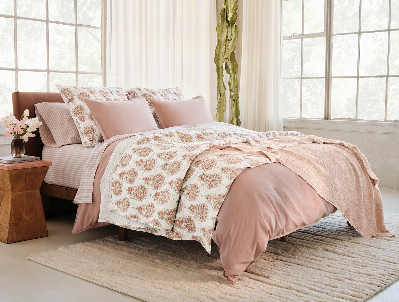 Coyuchi Topanga Matelassé blanket styled on a bed with blush pink bedding.