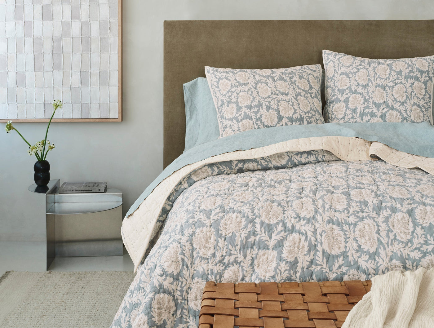 Close-up of Coyuchi Robles duvet and shams in sage and blush floral print on styled bed.