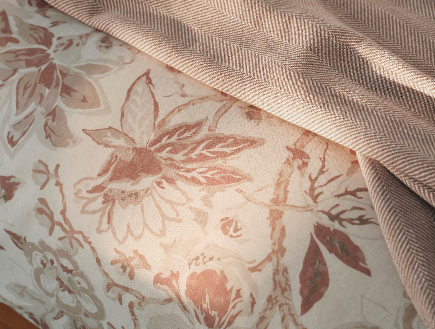 Close-up of Coyuchi Sea Bloom duvet cover's blush floral print with herringbone reverse.