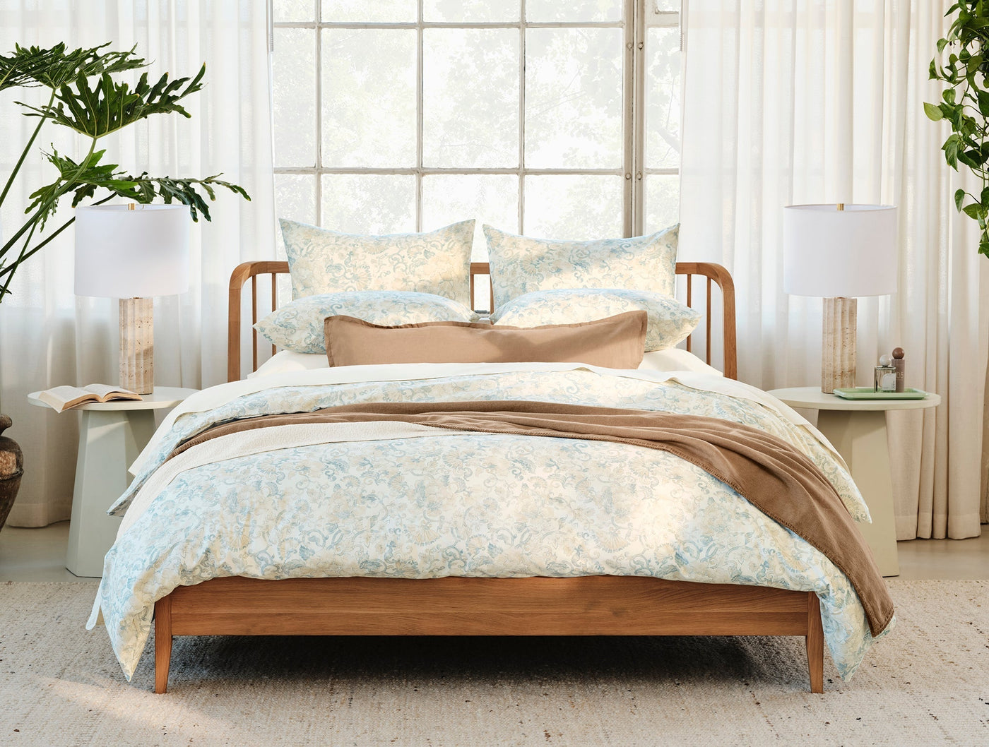 Coyuchi Solana Print duvet cover styled on bed with matching shams, soft blue floral pattern.