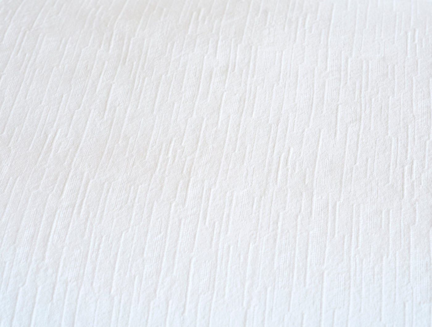 Close-up of Coyuchi Toro Canyon duvet cover showing white textured weave detail.