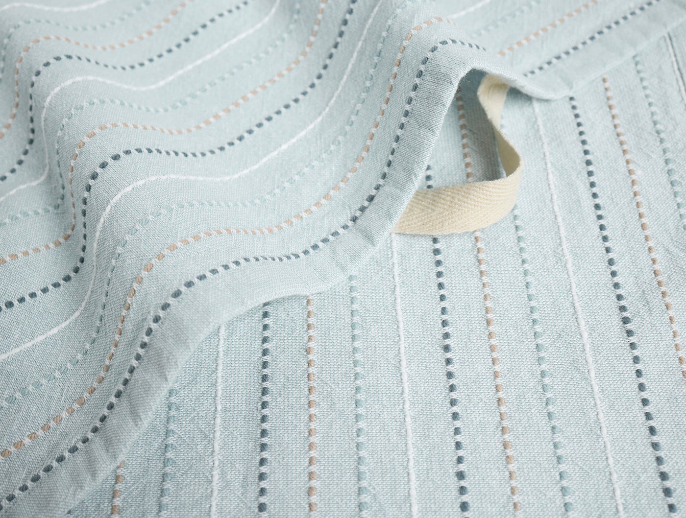 Coyuchi Fringe Stripe hand towel in mist, close-up of dotted stripe weave and folded edge.