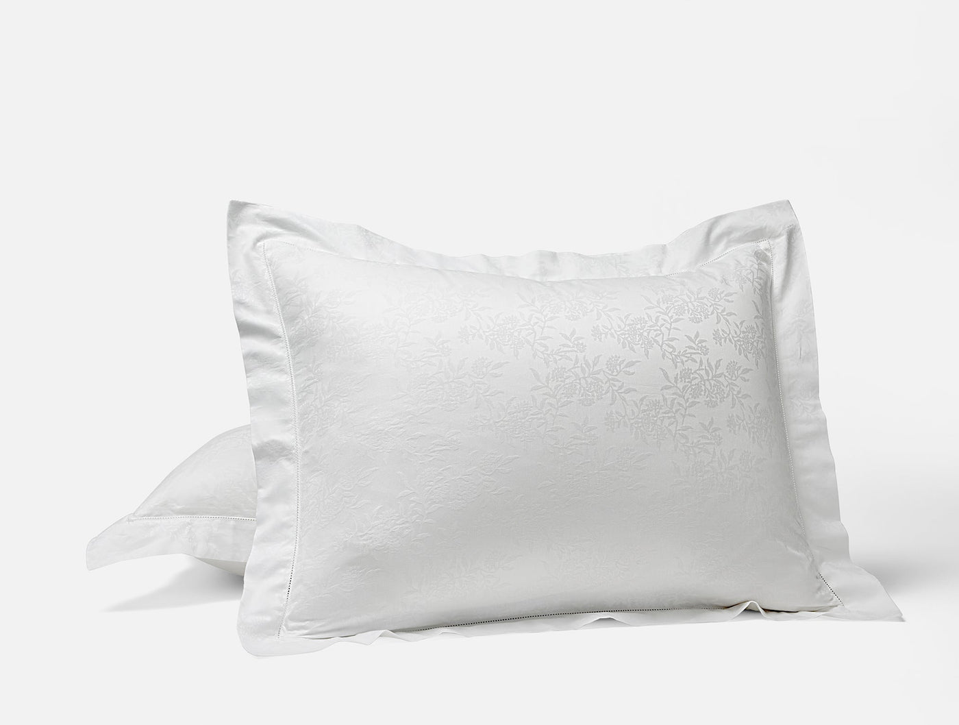 Coyuchi Heirloom Sateen Jacquard pillow sham in white with floral jacquard detail.