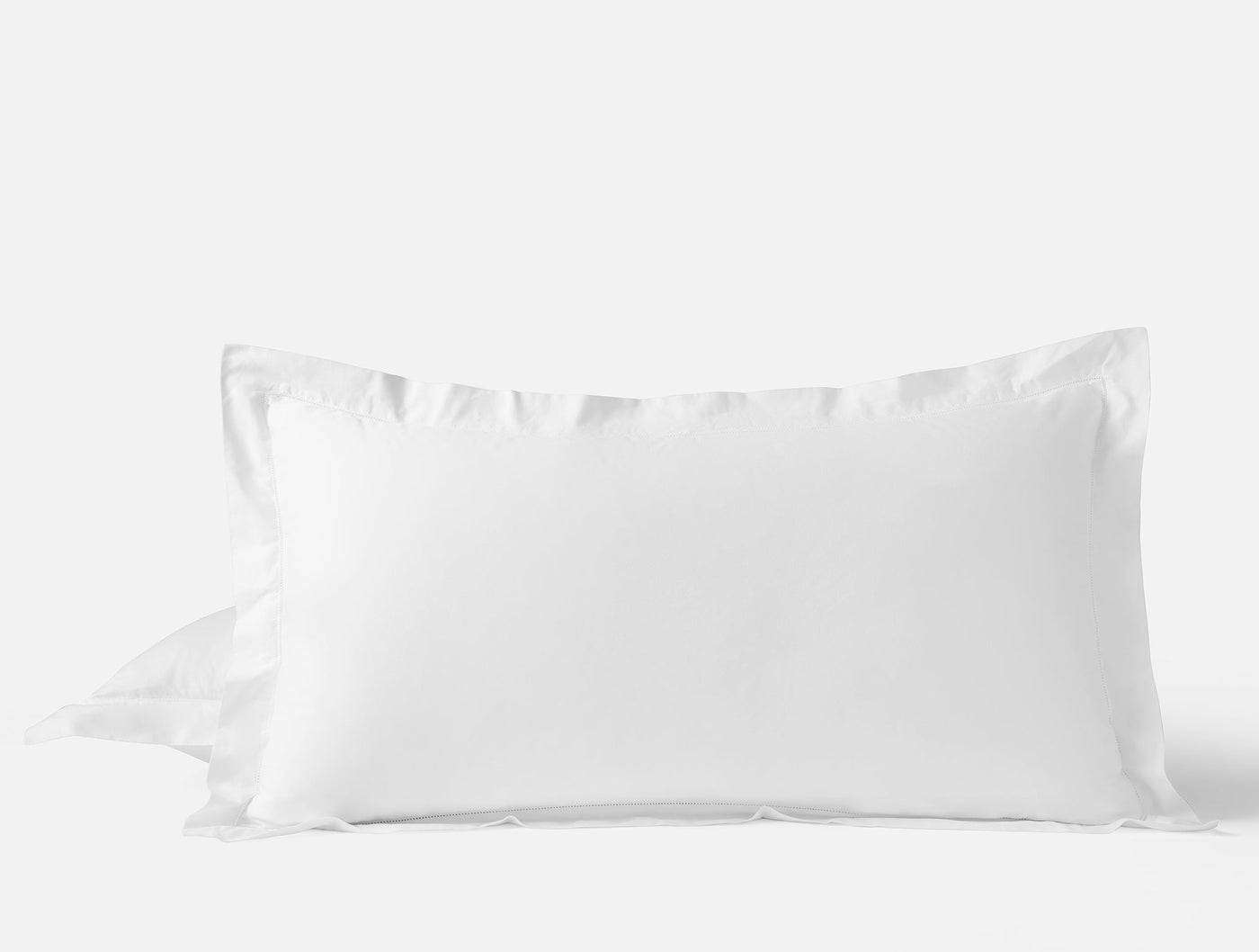 White sateen pillow sham with ruffled edge detail, displayed upright against a light background.