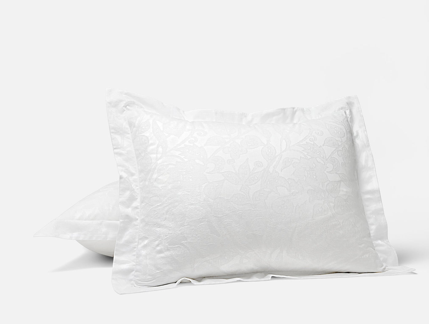 Coyuchi Heritage Percale Jacquard pillow sham in white with floral pattern.