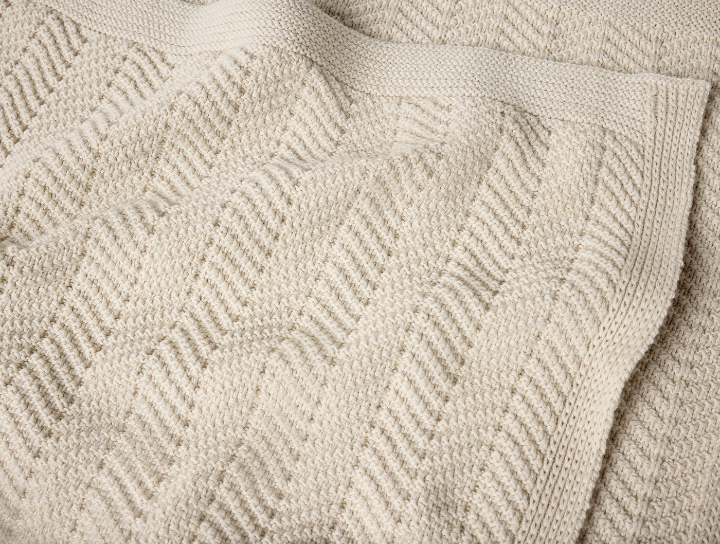 Close-up of Coyuchi Hermosa Knit throw's chevron texture in natural ivory.