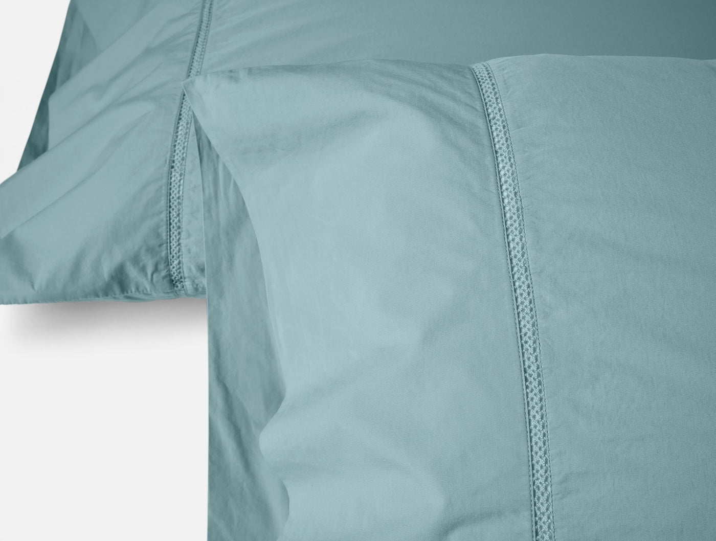 Close-up of Coyuchi Lattice Percale pillowcase pair in seafoam with lattice-stitched hem detail.