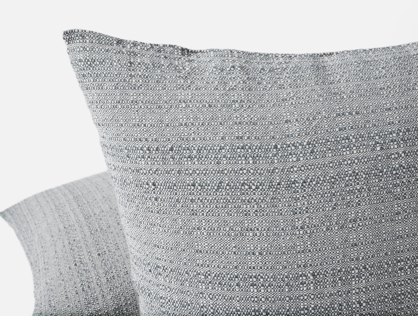 Close-up of Coyuchi Lido pillow cover corner showing heathered grey woven texture.