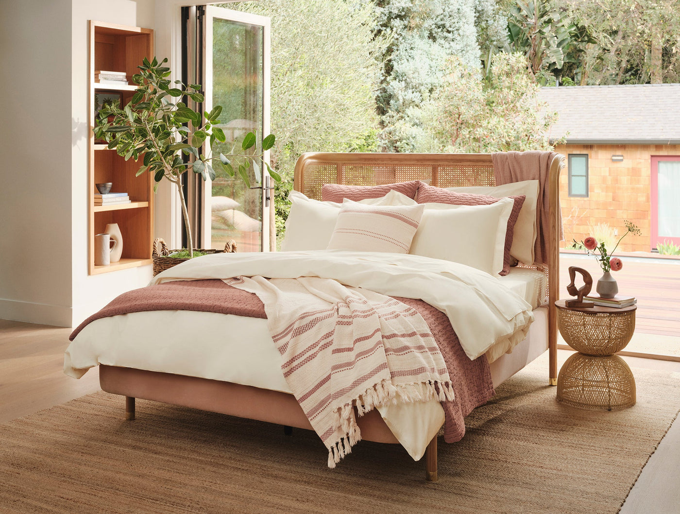 Ivory Coyuchi Refined Percale duvet styled on bed with rose pink accents and fringed throw.