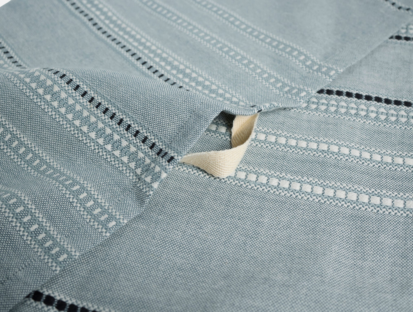 Close-up of Coyuchi Lobos hand towel in slate, showing woven stripe and ladder hem detail.