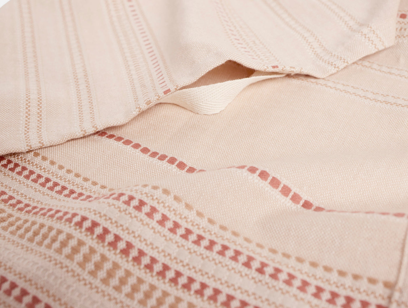 Close-up of Coyuchi Magnolia hand towel showing blush stripe and ladder lace detail.