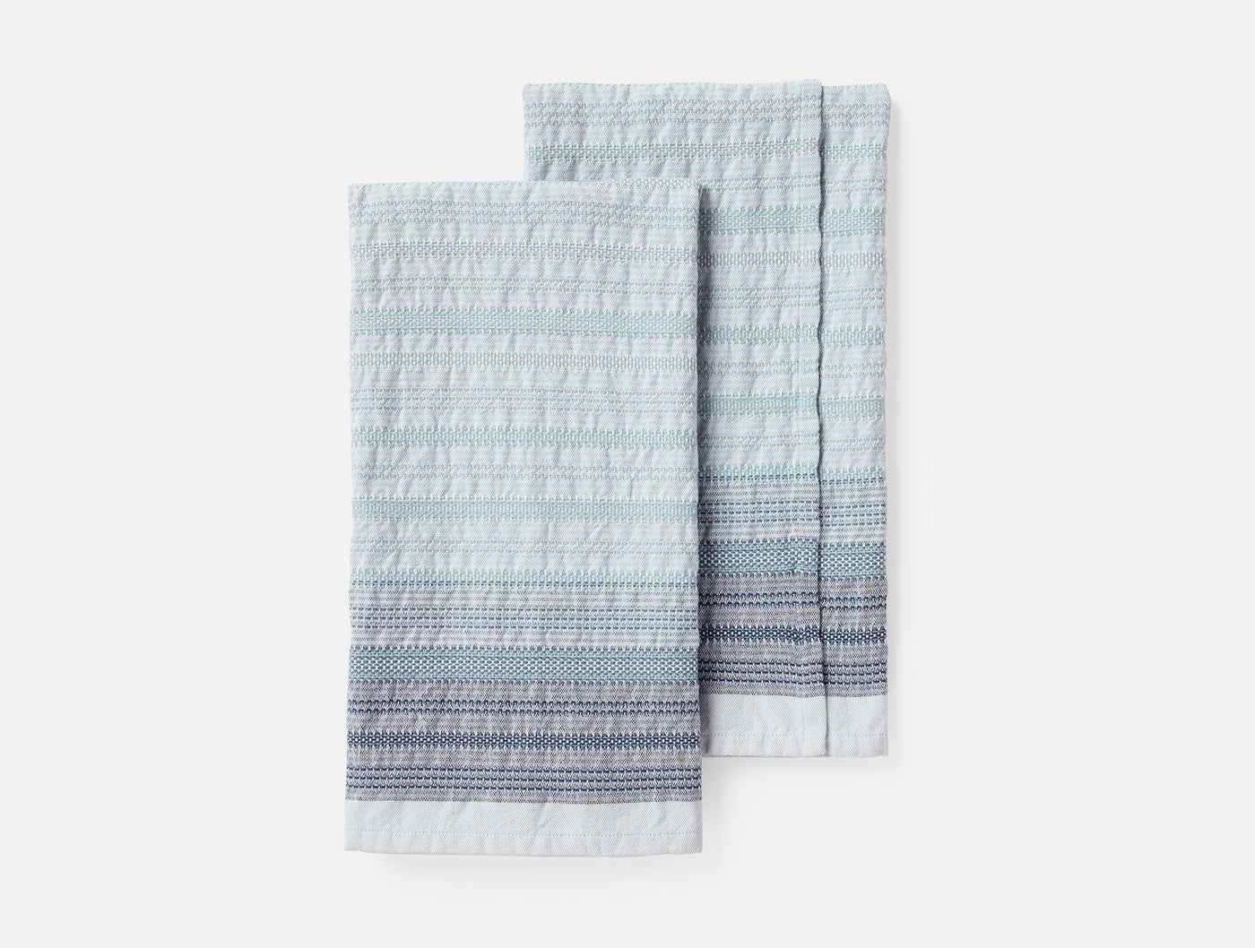 Coyuchi Magnolia hand towel pair, light blue with textured stripe border detail.