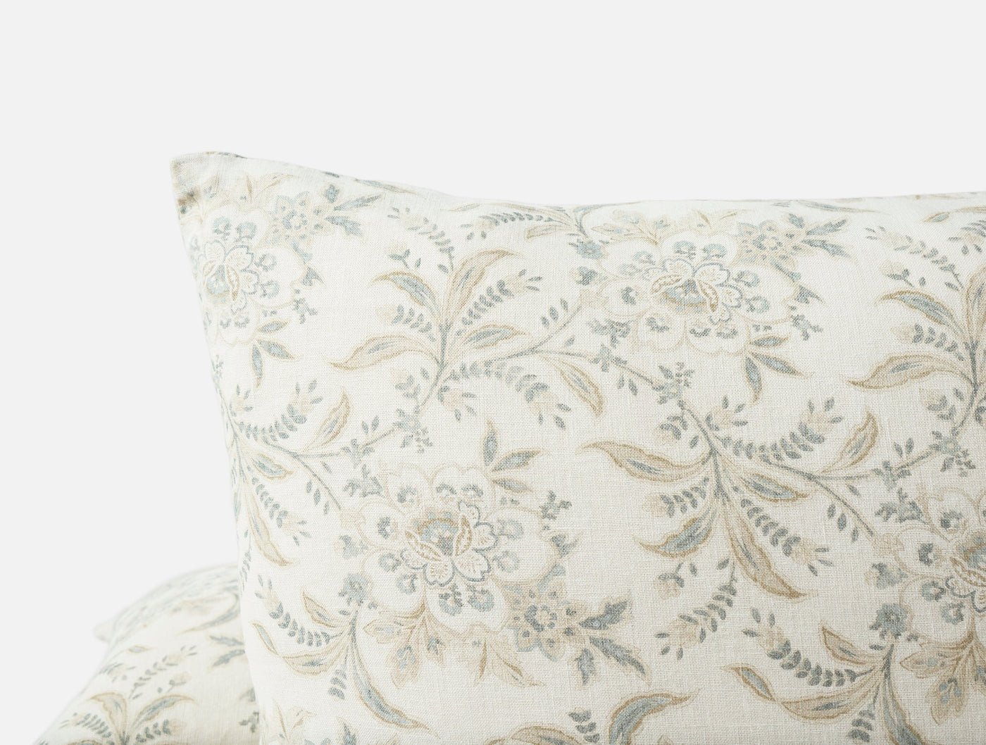 Close-up of Coyuchi Marguerite Print pillow corner, ivory linen with sage floral vine pattern.