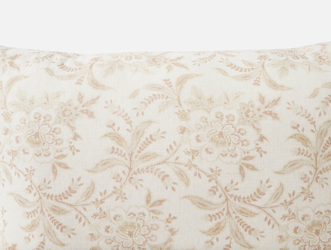 Close-up of ivory linen pillow cover with tone-on-tone floral and leaf print in sand.