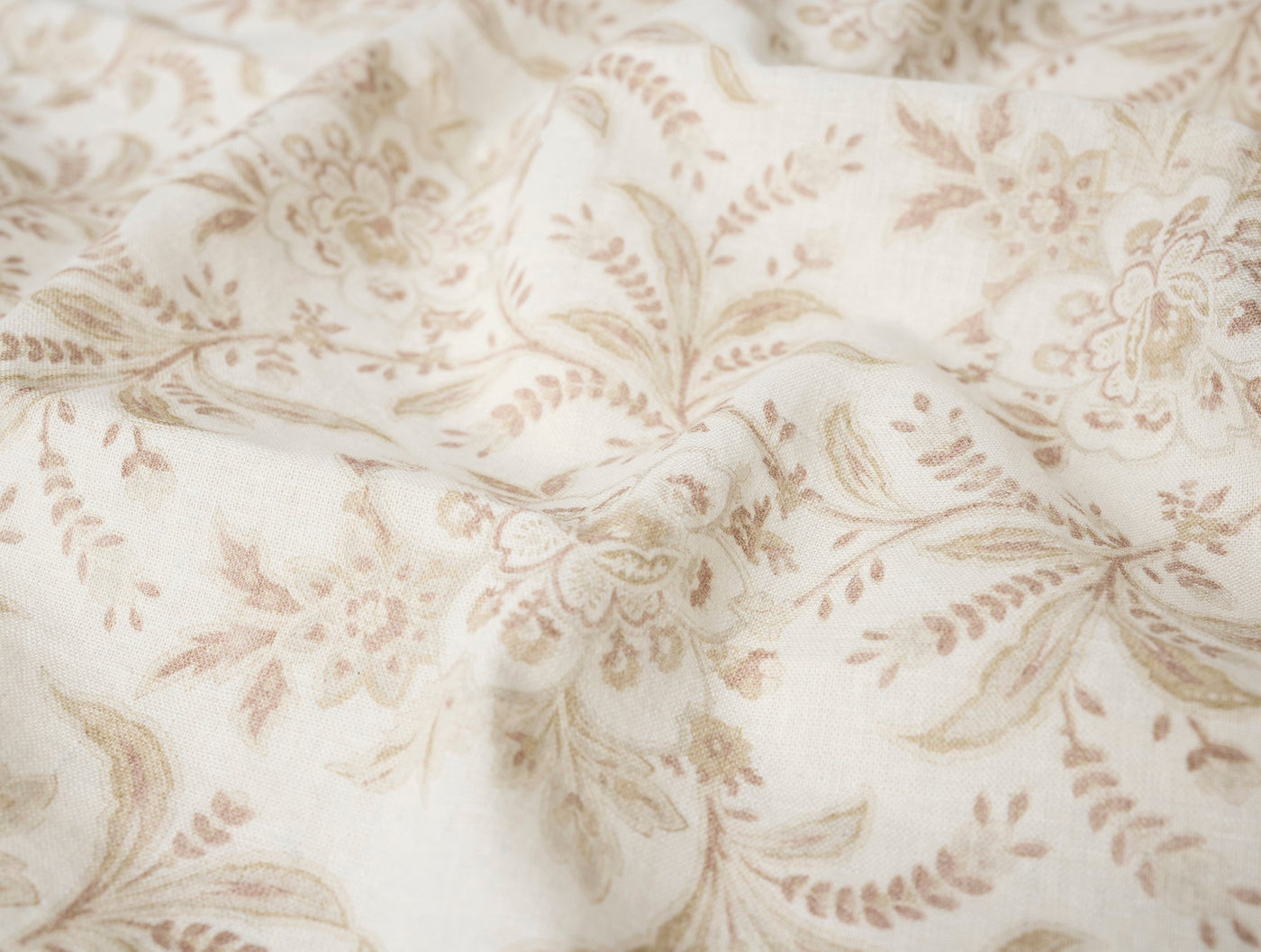 Close-up of ivory linen fabric with soft taupe floral and leaf print pattern.