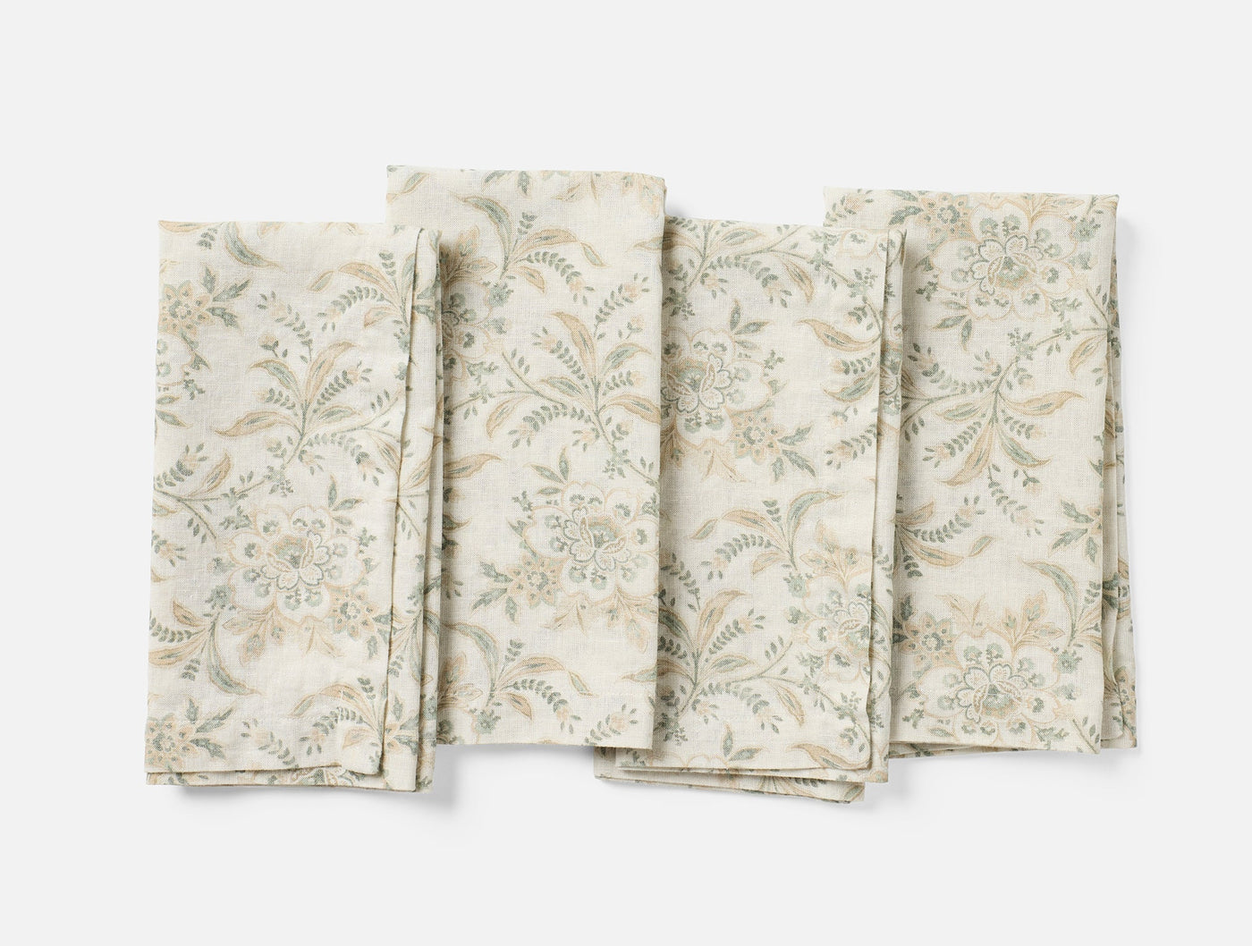Four Coyuchi Marguerite Print napkins fanned flat, ivory with sage and taupe floral print.
