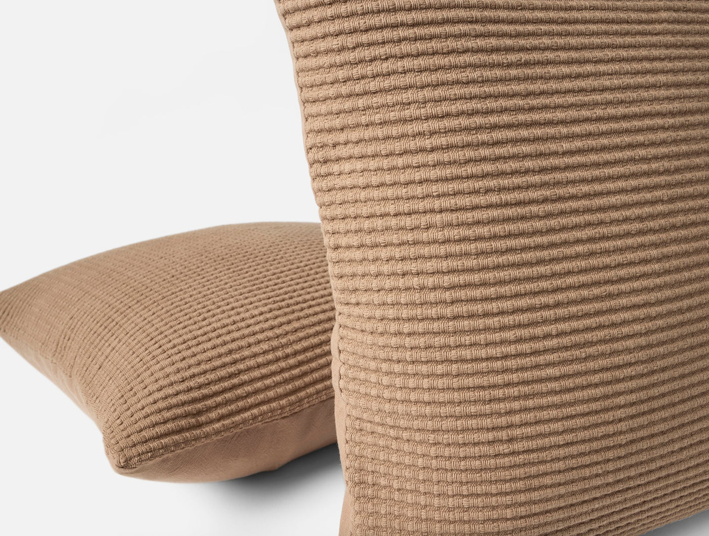 Close-up of Coyuchi Marshall pillow covers in camel, showing ribbed waffle-knit texture detail.