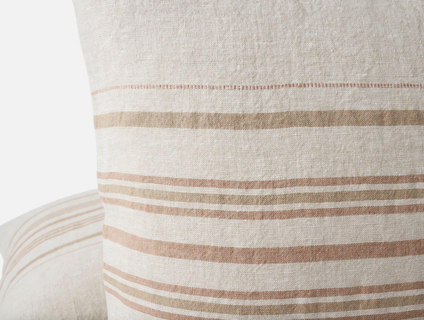 Close-up of Coyuchi Mojave Linen pillow corner showing tan stripe pattern on ivory linen.