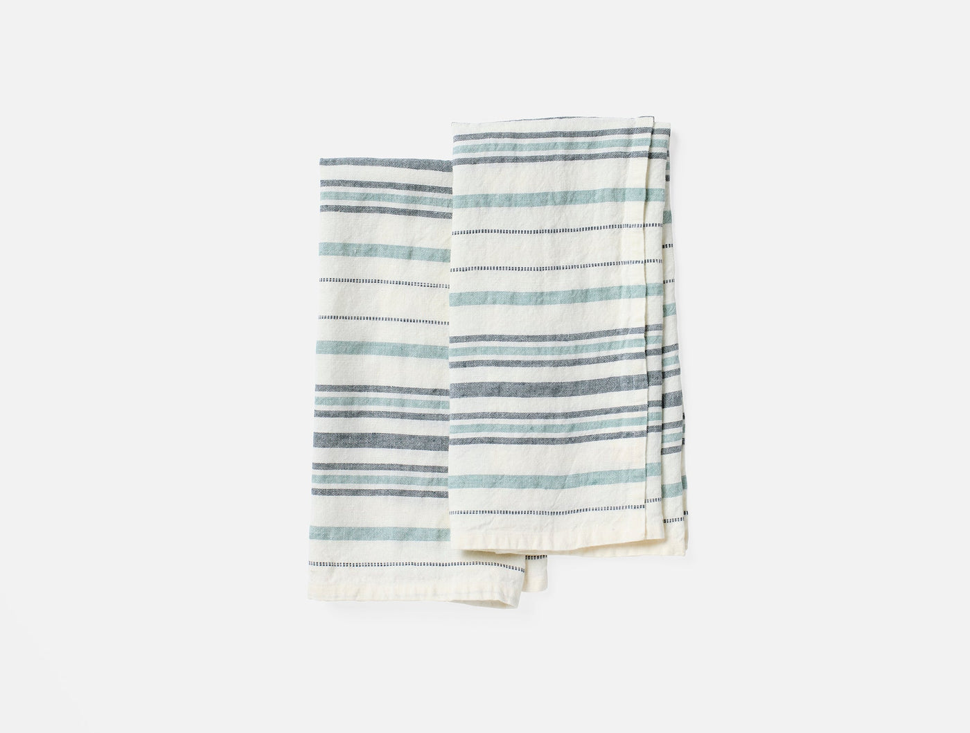 Pair of Coyuchi Mojave linen hand towels with slate and mist blue stripes and fringe hem.