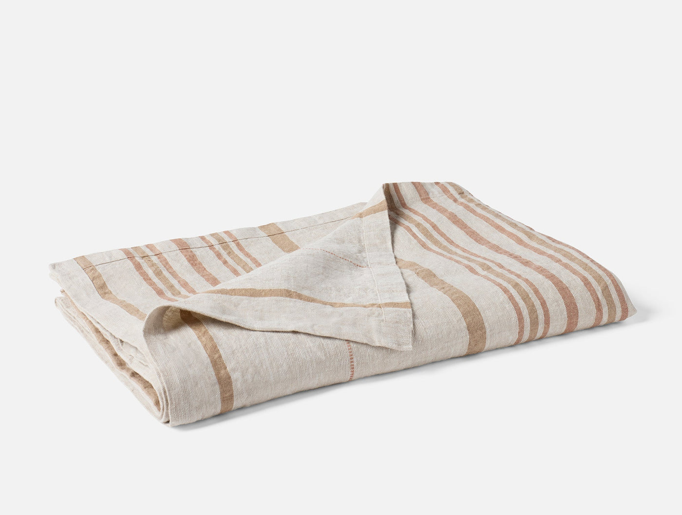 Close-up of folded Mojave Linen throw showing caramel stripe pattern on natural linen.