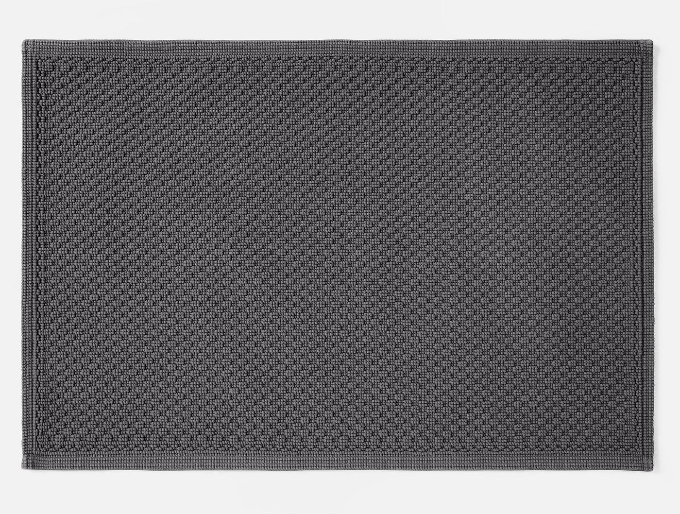 Coyuchi Moonstone bath rug in charcoal, showing full waffle-weave texture and border detail.