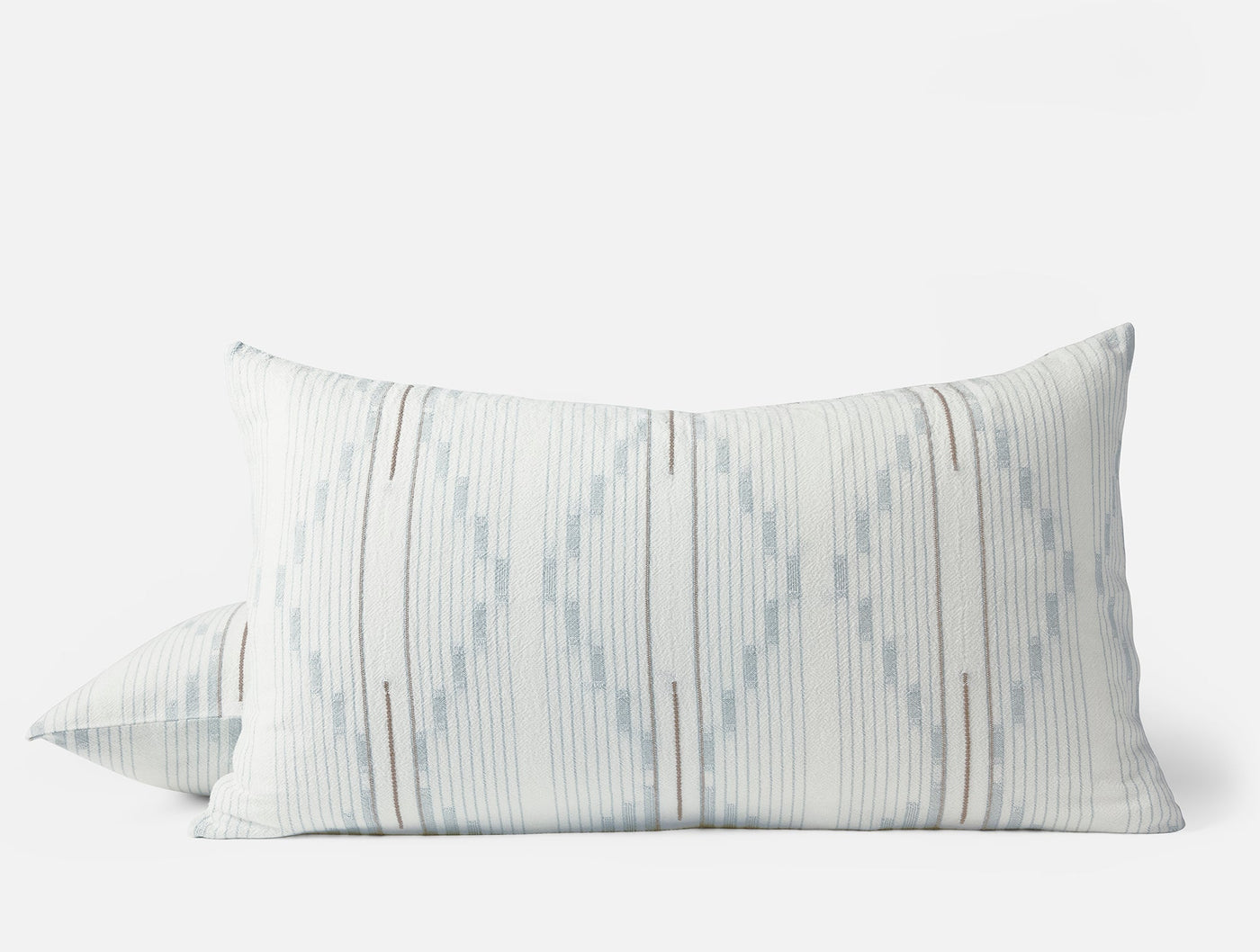 Close-up of Coyuchi Morelia sham pair showing ikat diamond pattern in pale blue on white.