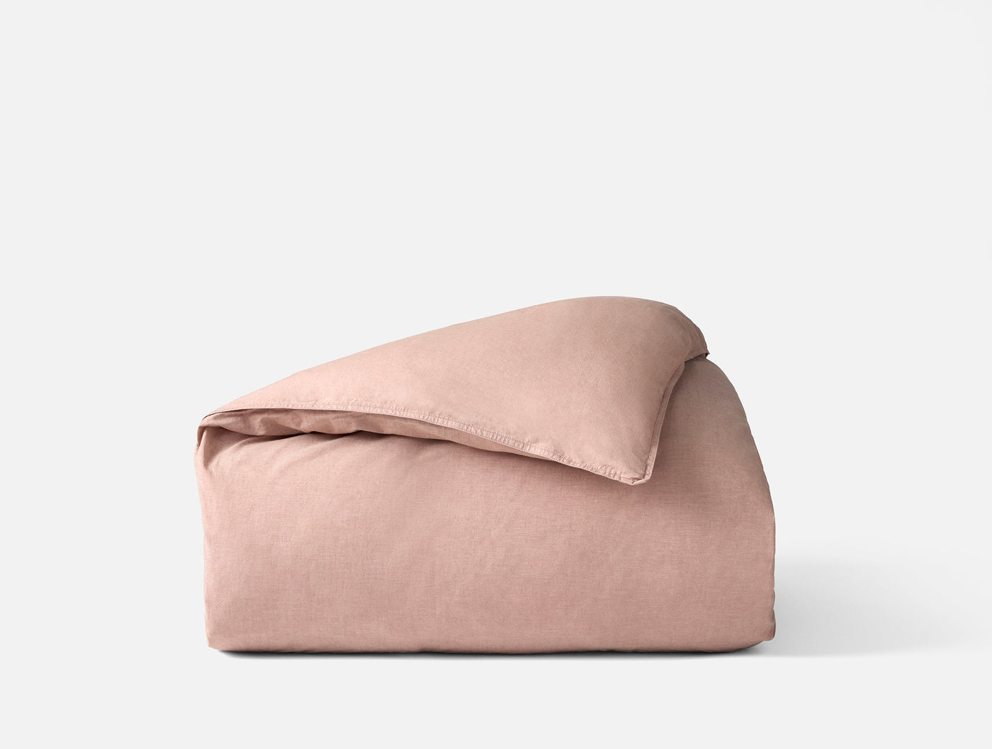 Coyuchi Crinkled Percale duvet cover folded, showing textured blush fabric surface.
