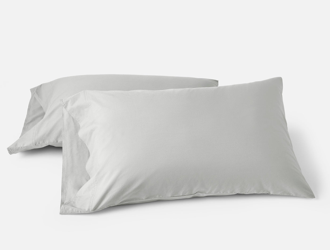 Two silver Coyuchi Crinkled Percale pillowcases stacked at an angle on white background.