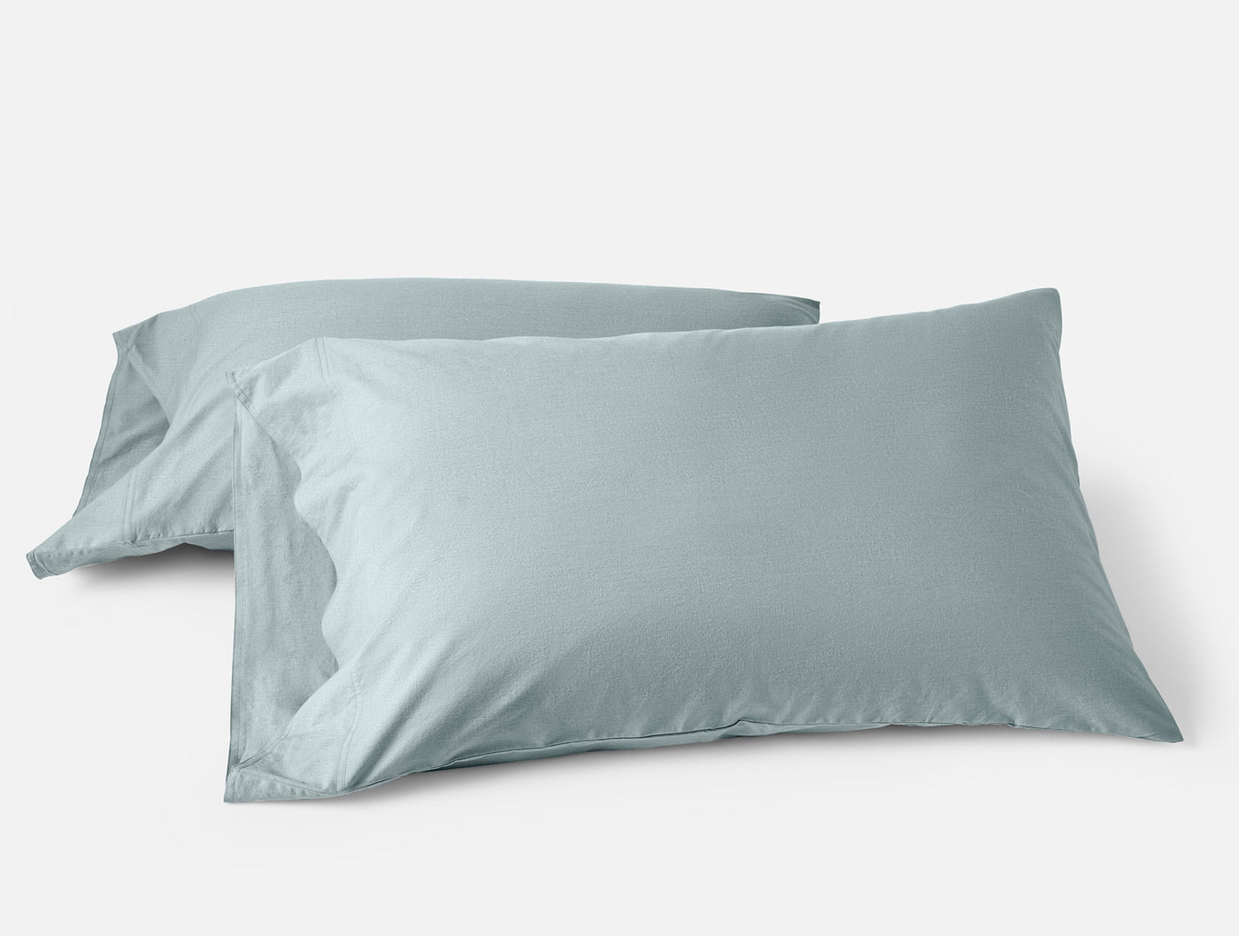 Two Coyuchi Crinkled Percale pillowcases in mist blue, soft textured finish, pair stacked.