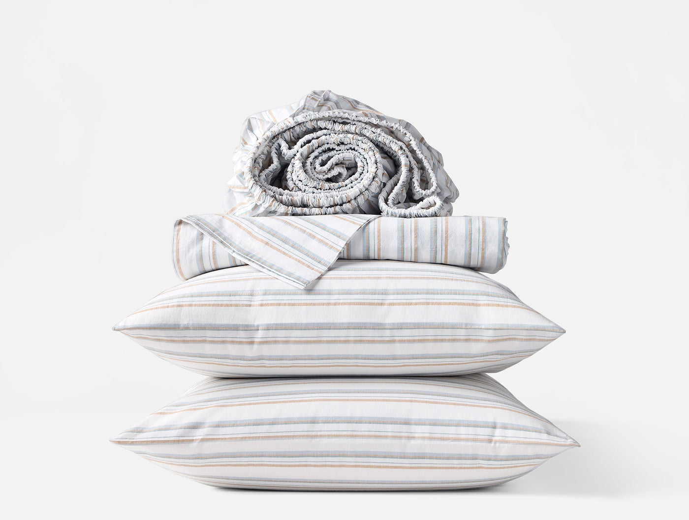 Stacked Coyuchi Crinkled Percale sheet set with multicolor stripe pillowcases and rolled sheets.