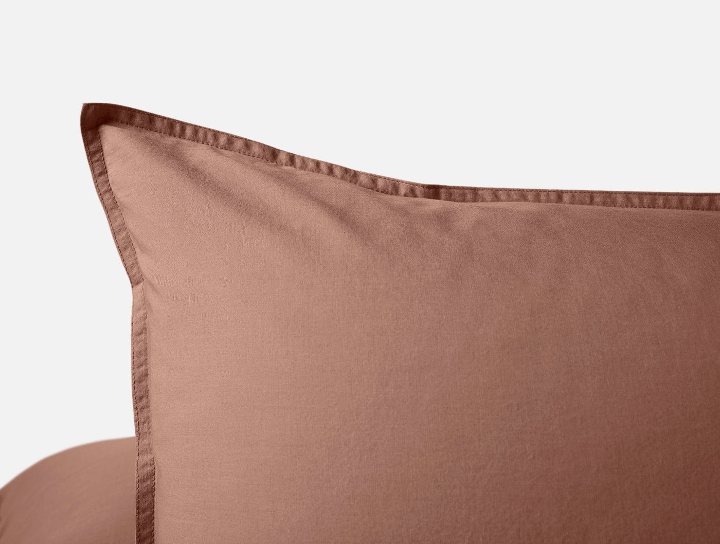 Close-up of terracotta Coyuchi Crinkled Percale sham corner with stitched flange detail.