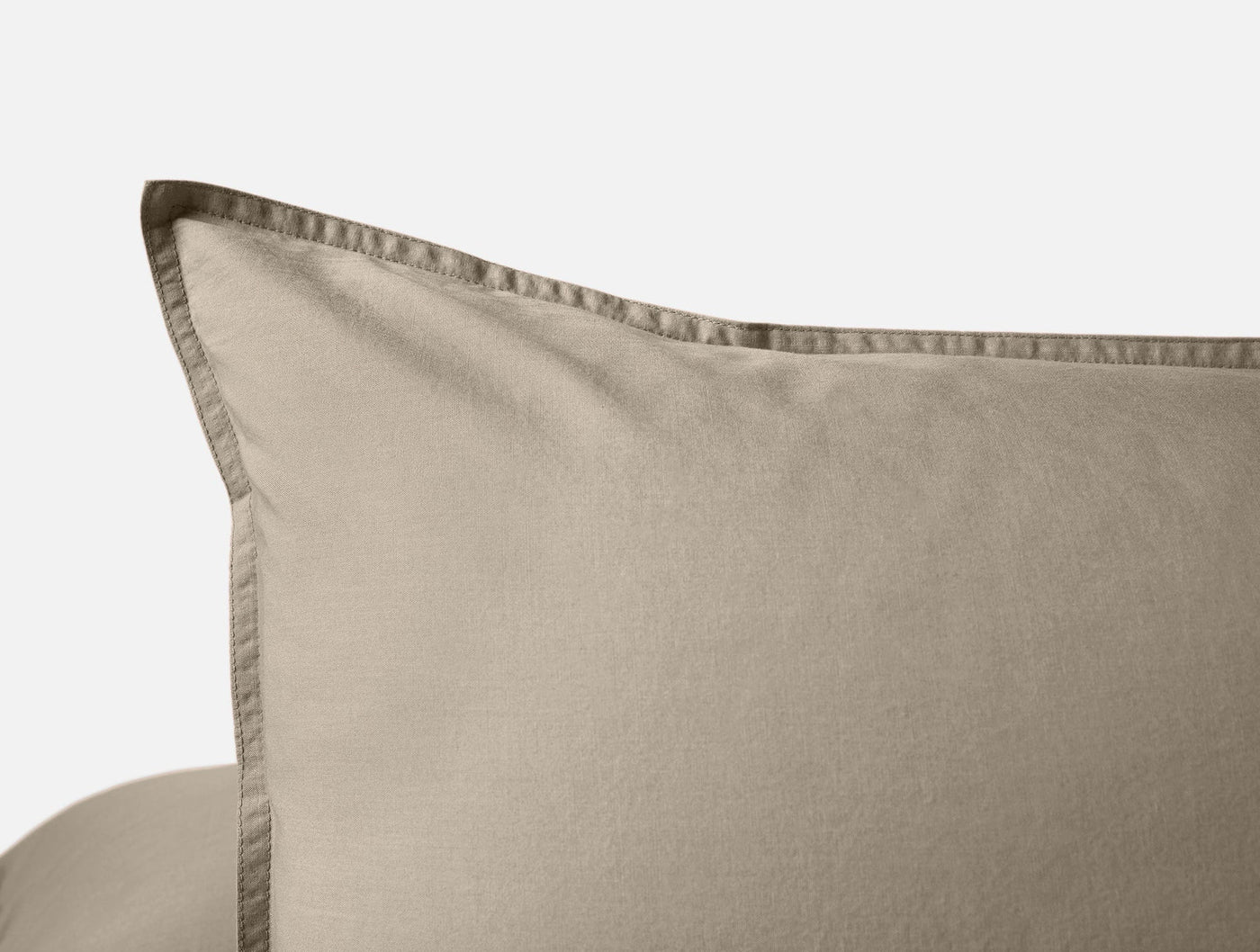 Close-up of taupe Coyuchi Crinkled Percale pillowcase corner showing stitched hem detail.