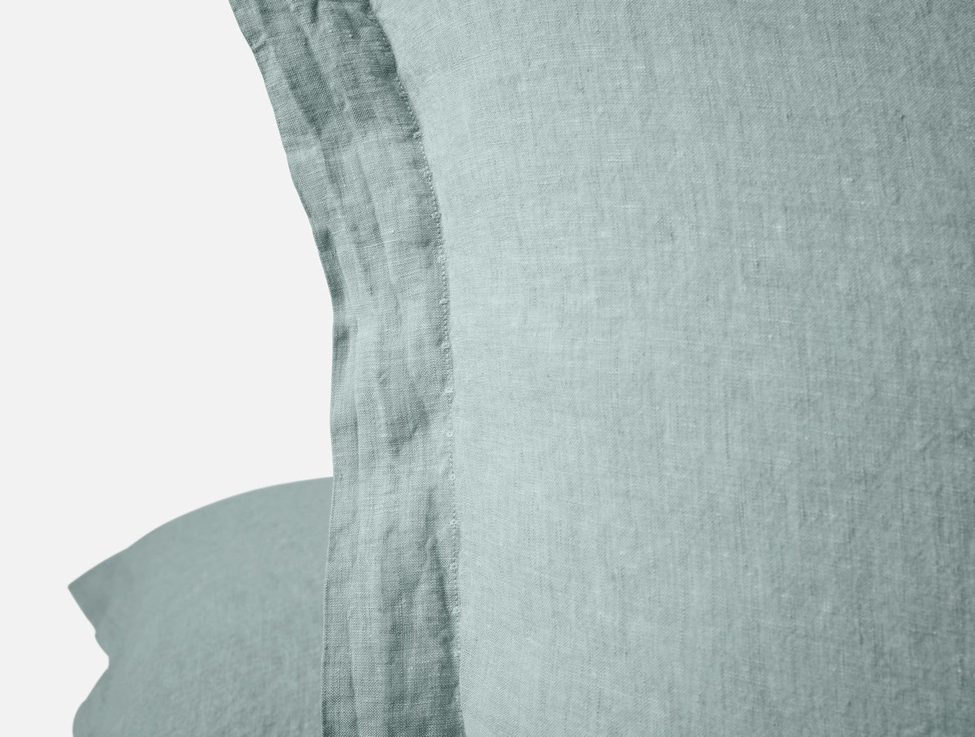 Close-up of Coyuchi Relaxed Linen sham edge in sage, showing frayed hem detail.