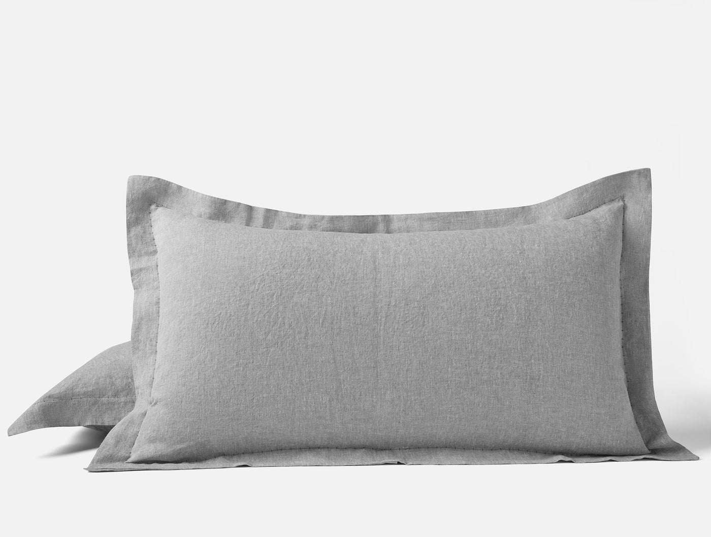 Dove grey linen pillow shams stacked, showing flanged edge detail.