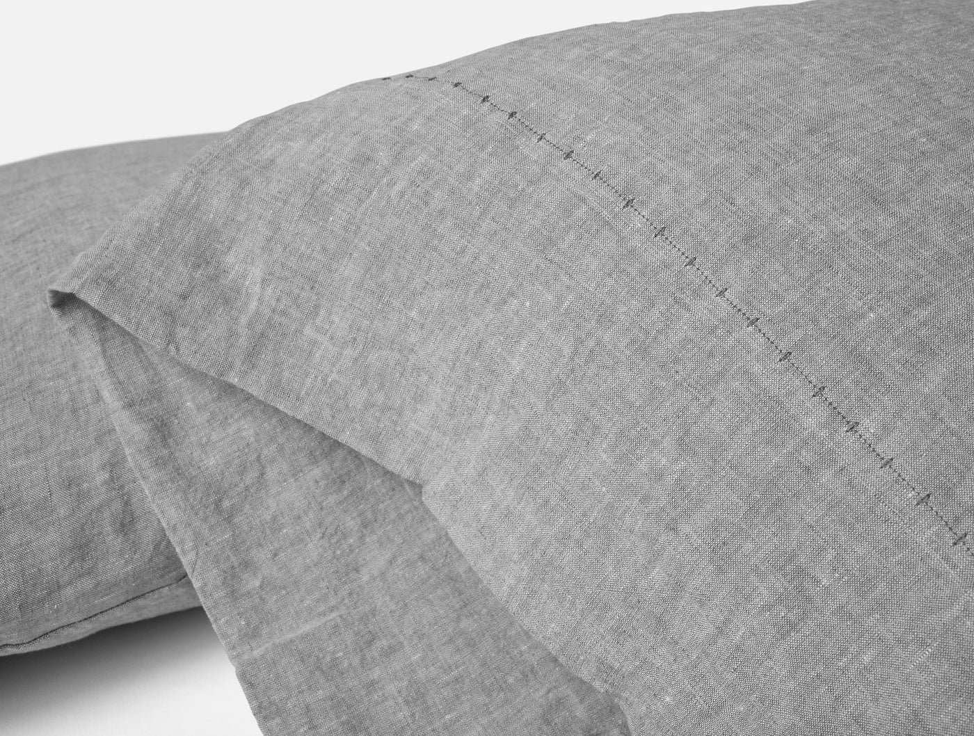 Close-up of Coyuchi Relaxed Linen pillowcase hem detail in heathered grey.