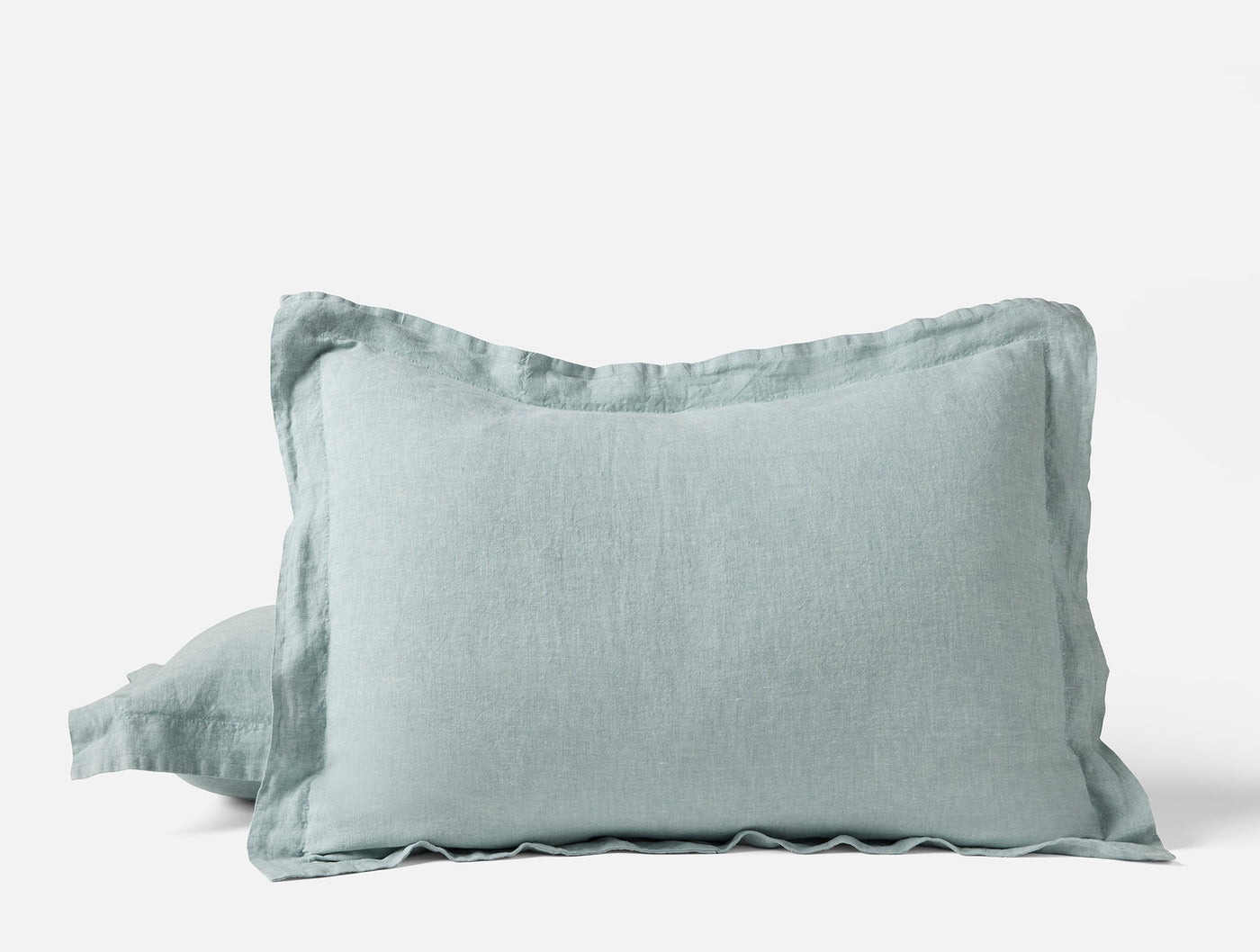 Seafoam linen pillow sham with contrast flange border, shown as a stacked pair.