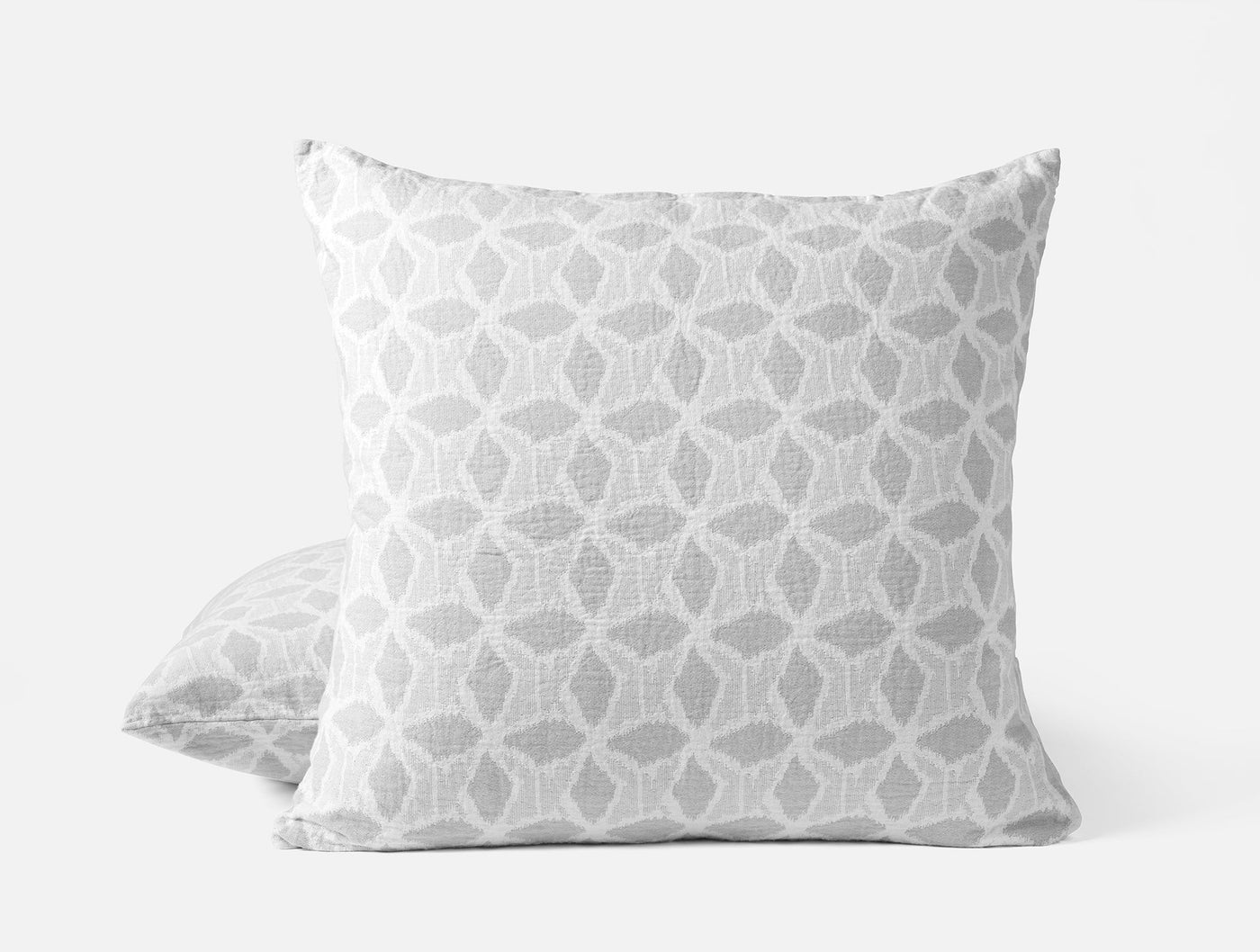 Front and back view of Coyuchi Palomar sham in silver geometric ikat pattern on white.