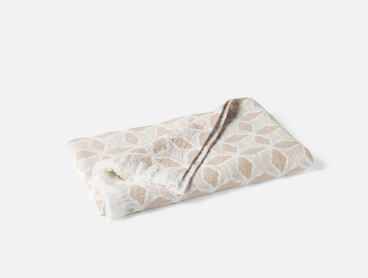 Coyuchi Palomar throw folded, ivory and sand geometric pattern on textured cotton.