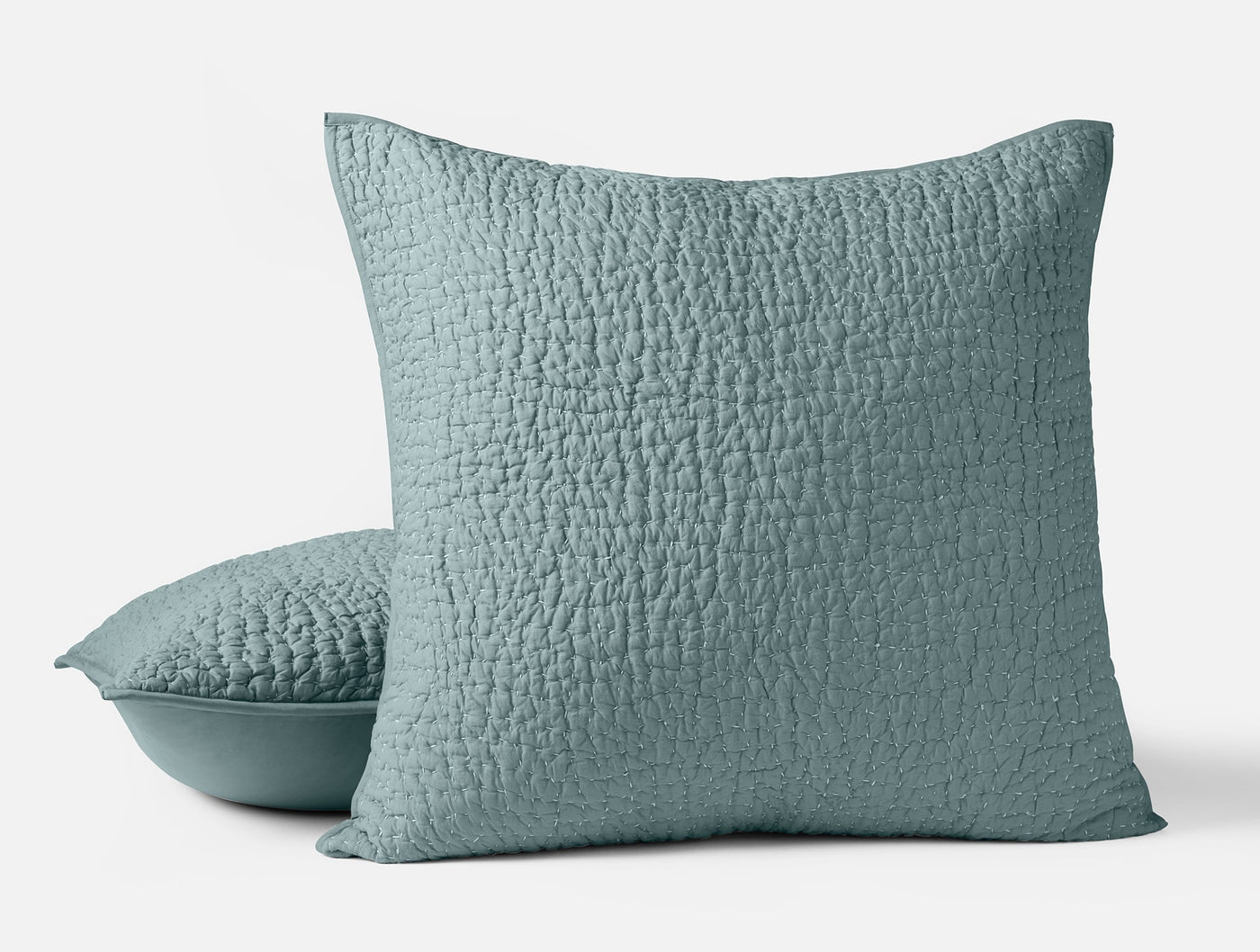 Close-up of two Coyuchi Pebbled Handstitched shams in dusty teal with quilted texture.