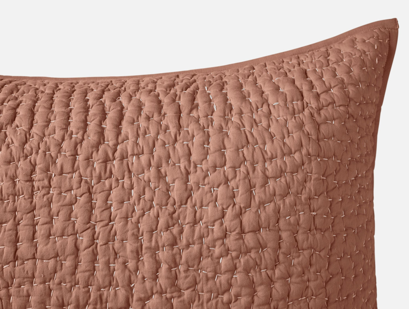 Close-up of terracotta Coyuchi Pebbled Handstitched sham showing quilted texture and trim detail.
